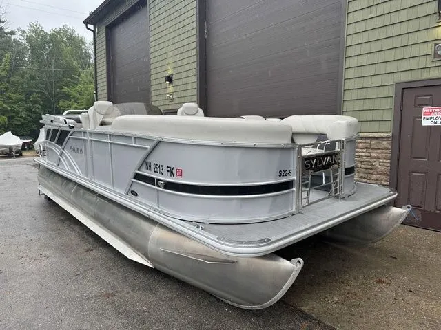 Slide: The Image of 2022 Sylvan 8522 LZ pontoon boat parked outside a building on a rainy day. - 2