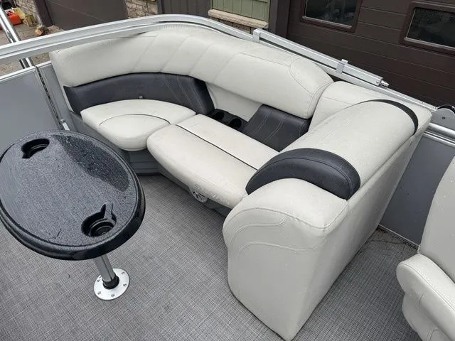 Slide: The Image of 2022 Sylvan 8522 LZ boat interior with gray seating and a small table. - 23