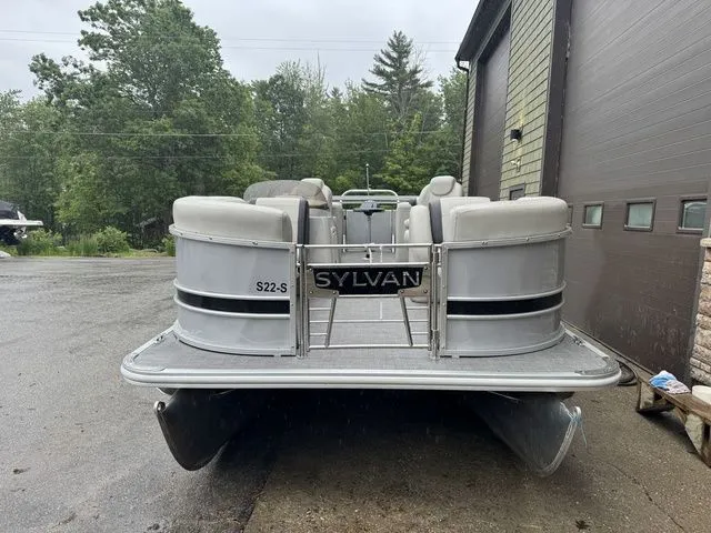 Slide: The Image of 2022 Sylvan 8522 LZ pontoon boat parked outdoors near a building. - 3