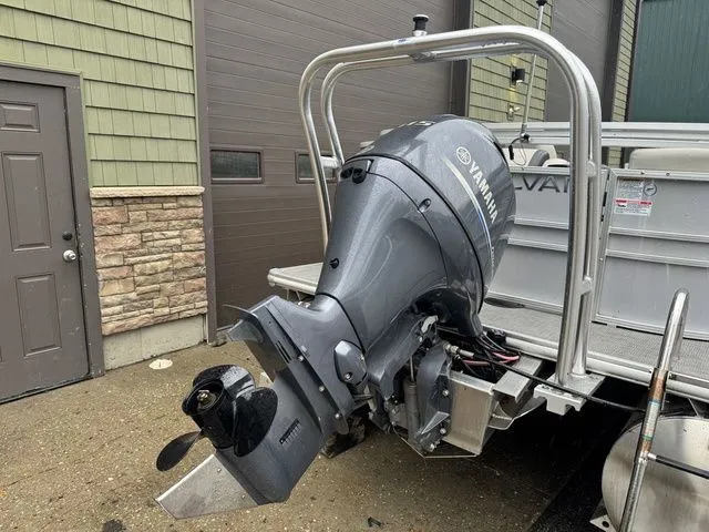 Slide: The Image of 2022 Sylvan 8522 LZ boat with Yamaha outboard motor, parked near a garage. - 6