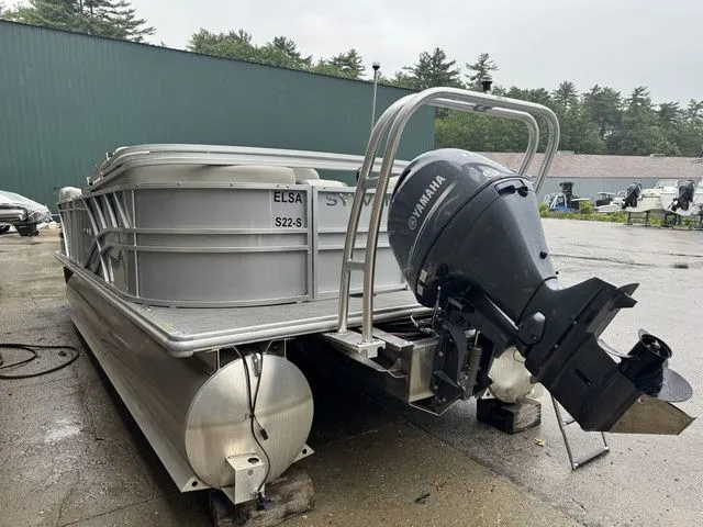 Slide: The Image of 2022 Sylvan 8522 LZ pontoon boat with Yamaha outboard motor, parked outdoors. - 8