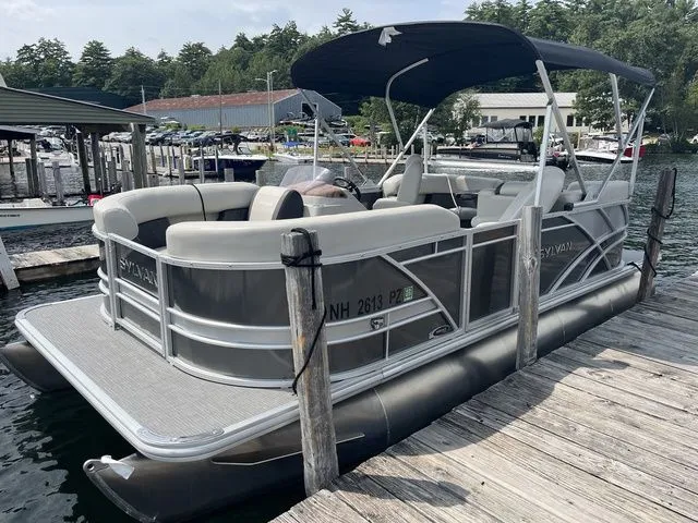 Slide: The Image of 2022 Sylvan 8520 LZ pontoon boat docked at a marina with canopy. - 1