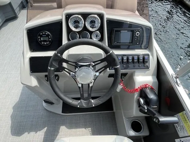 Slide: The Image of 2022 Sylvan 8520 LZ boat dashboard with steering wheel, gauges, and control panel. - 12