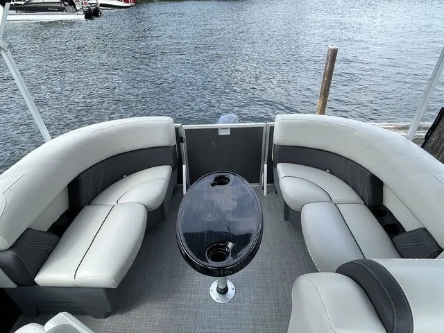 Slide: The Image of 2022 Sylvan 8520 LZ pontoon boat with stylish seating and table on a calm lake. - 16