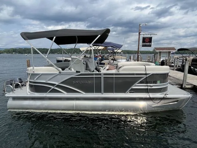 Slide: The Image of 2022 Sylvan 8520 LZ pontoon boat docked on a lake under cloudy skies. - 4
