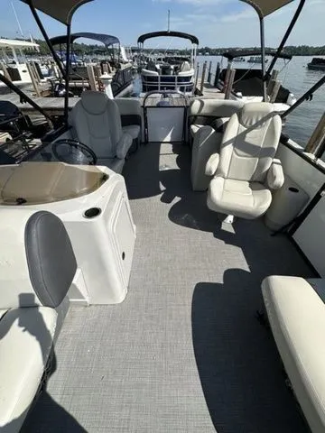 Slide: The Image of 2022 Sylvan X1 boat interior with plush seating, docked at a marina. - 4