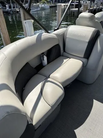 Slide: The Image of 2022 Sylvan X1 boat interior with plush seating, docked by the water. - 5