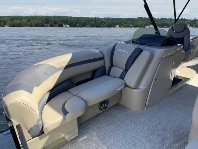 Slide: The Image of 2022 Sylvan L-3 CLZ pontoon boat interior with plush seating on a serene lake. - 4