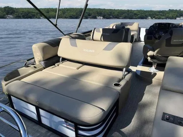 Slide: The Image of 2022 Sylvan L-3 CLZ pontoon boat with beige seating on a lake. - 5