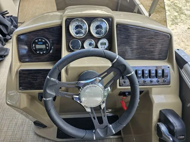 Slide: The Image of 2023 Sylvan 8522 CRS SG boat dashboard with steering wheel and control panel. - 4