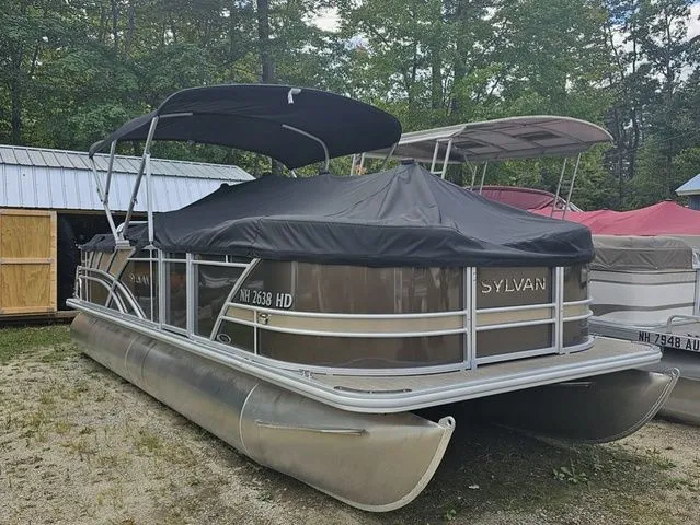 Slide: The Image of 2023 Sylvan 8522 CRS SG pontoon boat with cover, parked outdoors. - 8