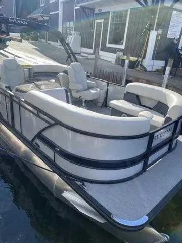 Slide: The Image of 2023 Sylvan X1 pontoon boat docked, featuring spacious seating and modern design. - 1