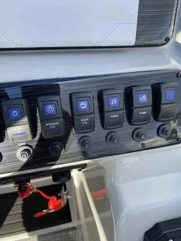Slide: The Image of Control panel of 2023 Sylvan X1 boat with labeled switches for various functions. - 11