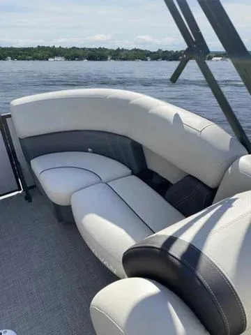 Slide: The Image of 2023 Sylvan X1 boat interior with plush seating on a serene lake. - 13