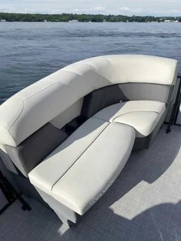 Slide: The Image of 2023 Sylvan X1 boat with plush seating, overlooking a serene lake view. - 6