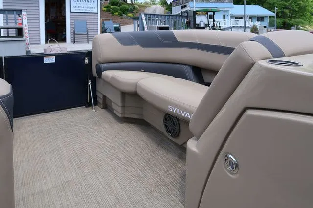 Slide: The Image of 2023 Sylvan L-3 DLZ BAR pontoon boat interior with beige seating and modern design. - 12