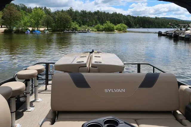 Slide: The Image of 2023 Sylvan L-3 DLZ BAR pontoon boat on a scenic lake with trees and blue sky. - 14