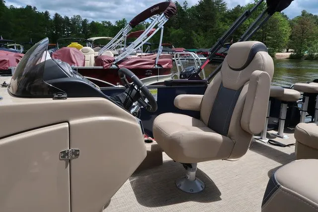 Slide: The Image of 2023 Sylvan L-3 DLZ BAR boat interior with beige captain's chair and steering console. - 9