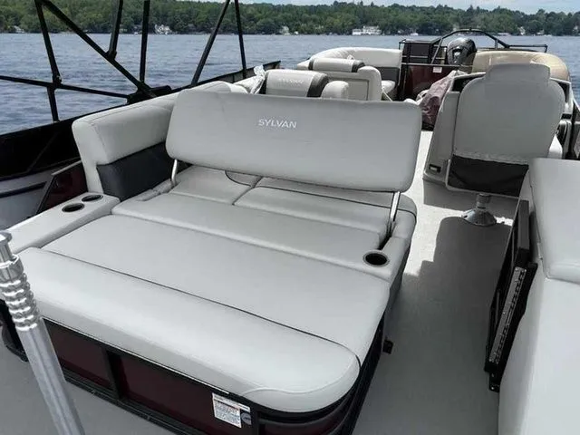 Slide: The Image of 2023 Sylvan X3 CLZ pontoon boat interior with plush seating on a serene lake. - 5