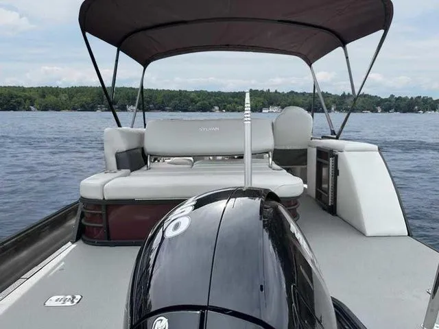 Slide: The Image of 2023 Sylvan X3 CLZ pontoon boat on a lake with canopy and seating. - 7