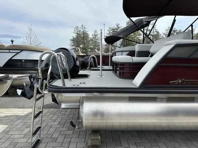 Slide: The Image of 2023 Sylvan X3 CLZ pontoon boat with Mercury outboard motor, docked on paved surface. - 8