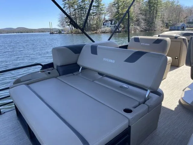 Slide: The Image of 2023 Sylvan L-5 CLZ pontoon boat with luxurious seating on a serene lake. - 10
