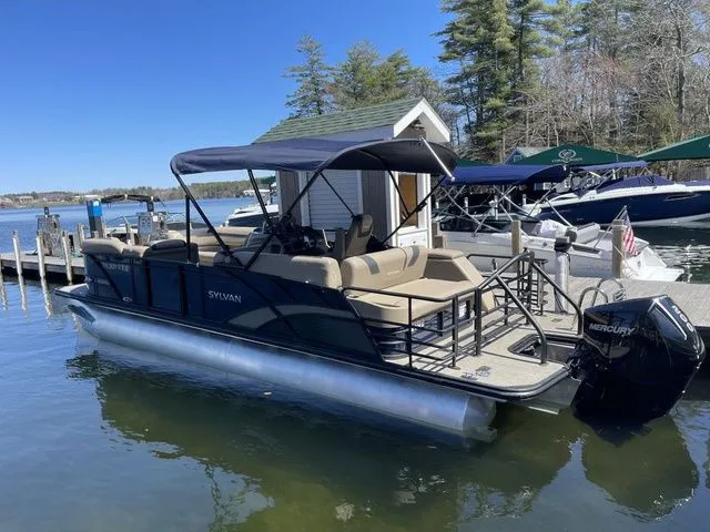 Slide: The Image of 2023 Sylvan L-5 CLZ pontoon boat docked on a sunny day. - 2
