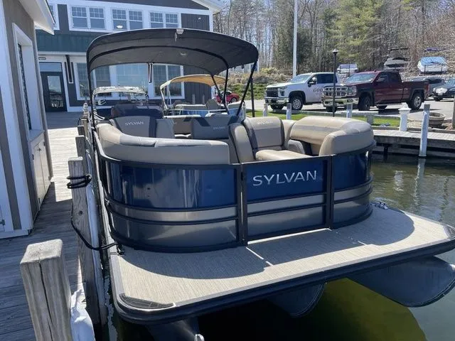 Slide: The Image of 2023 Sylvan L-5 CLZ pontoon boat docked at a marina, featuring spacious seating. - 4