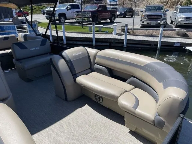 Slide: The Image of 2023 Sylvan L-5 CLZ pontoon boat with luxurious seating at a marina. - 5