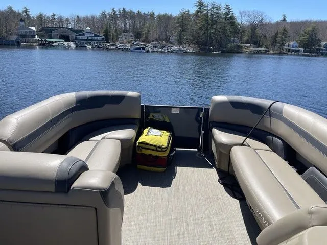 Slide: The Image of 2023 Sylvan L-5 CLZ pontoon boat interior with beige seating on a lake. - 7