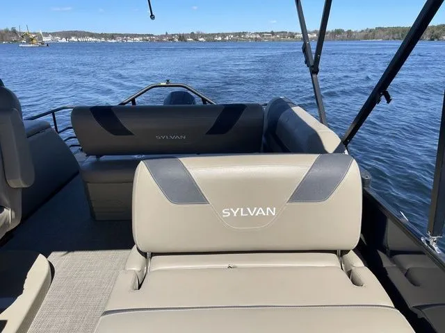 Slide: The Image of 2023 Sylvan L-5 CLZ boat interior with lake view, featuring comfortable seating. - 8