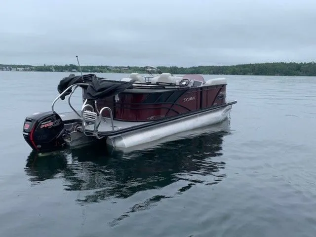 Slide: The Image of 2023 Sylvan X1 pontoon boat on calm lake waters. - 3