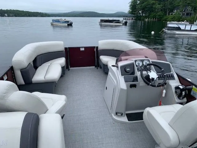 Slide: The Image of 2023 Sylvan X1 pontoon boat interior with plush seating on a serene lake. - 5
