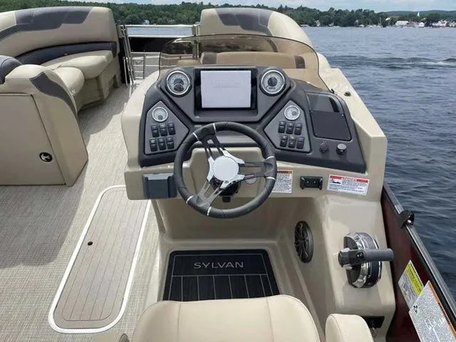 Slide: The Image of 2023 Sylvan L-1 DLZ boat dashboard with steering wheel and control panel on a lake. - 3