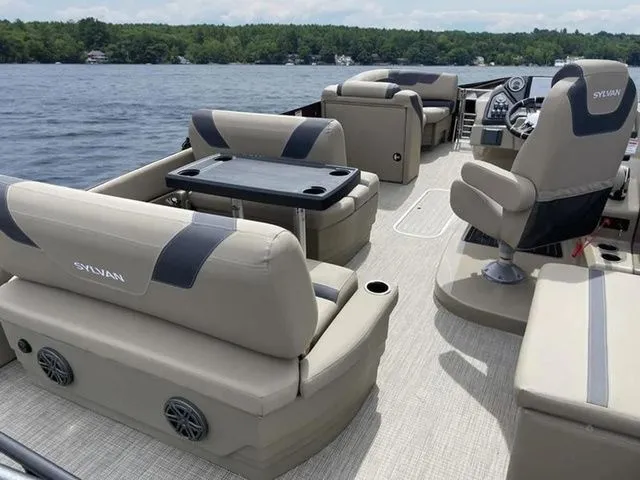 Slide: The Image of 2023 Sylvan L-1 DLZ pontoon boat interior with plush seating and lake view. - 6