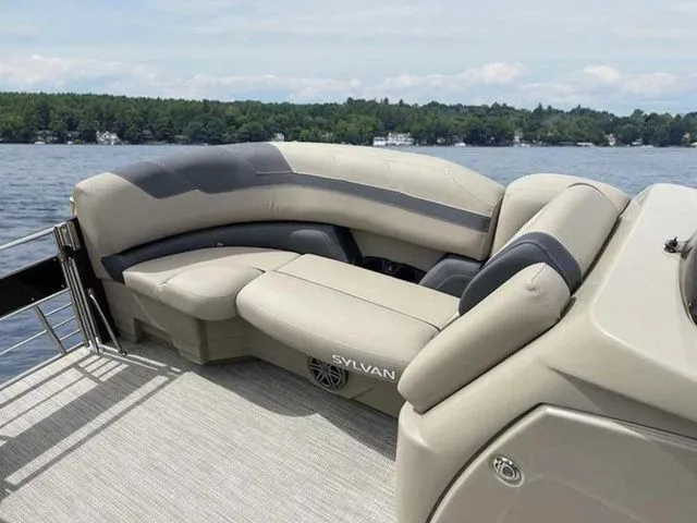Slide: The Image of 2023 Sylvan L-1 DLZ pontoon boat with luxurious seating on a serene lake. - 7