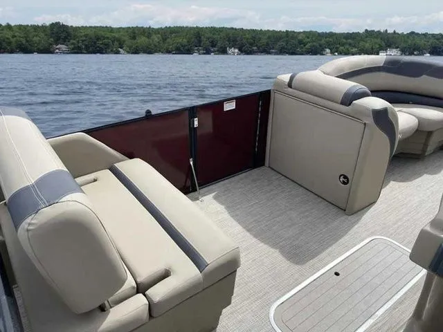 Slide: The Image of 2023 Sylvan L-1 DLZ pontoon boat interior with beige seating, on a lake. - 8