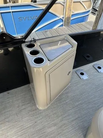 Slide: The Image of 2023 Sylvan L-5 DLZ Bar boat interior with cup holders and storage compartment. - 11