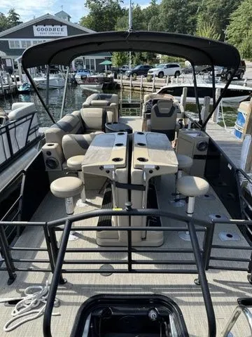 Slide: The Image of 2023 Sylvan L-5 DLZ Bar pontoon boat with seating and bar area at a marina. - 6