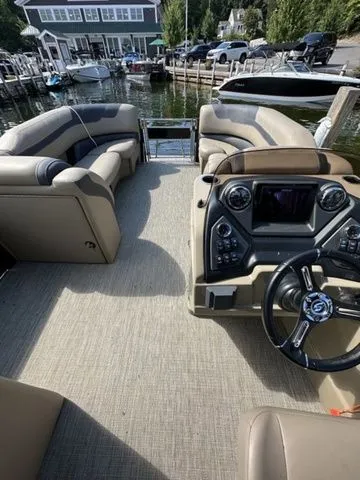 Slide: The Image of 2023 Sylvan L-5 DLZ Bar pontoon boat interior with plush seating and modern dashboard. - 8
