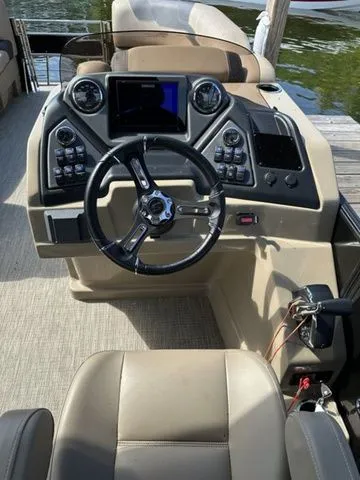 Slide: The Image of 2023 Sylvan L-5 DLZ Bar boat dashboard with steering wheel and control panel. - 9