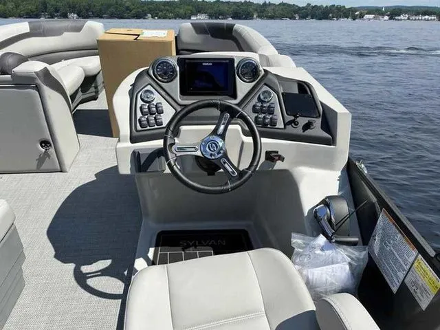 Slide: The Image of 2023 Sylvan L-5 CLZ boat interior with modern dashboard and steering on a lake. - 4