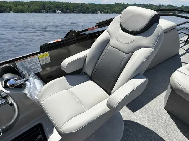 Slide: The Image of Captain's chair on 2023 Sylvan L-5 CLZ boat, overlooking serene lake waters. - 7
