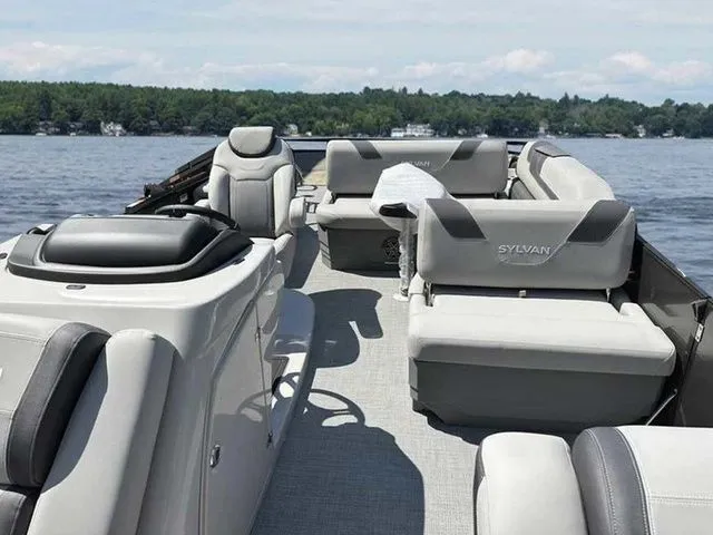 Slide: The Image of 2023 Sylvan L-5 CLZ pontoon boat with luxurious seating on a serene lake. - 8