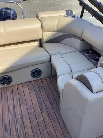 Slide: The Image of 2018 Harris 230 Sunliner Sport boat interior with beige seating and wood-style flooring. - 11