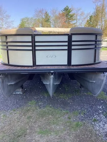 Slide: The Image of 2018 Harris 230 Sunliner Sport pontoon boat on gravel, surrounded by trees. - 7