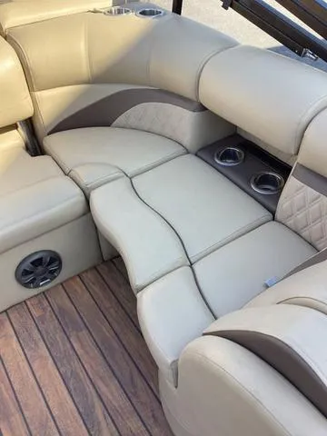 Slide: The Image of 2018 Harris 230 Sunliner Sport boat interior with beige seating and cup holders. - 9