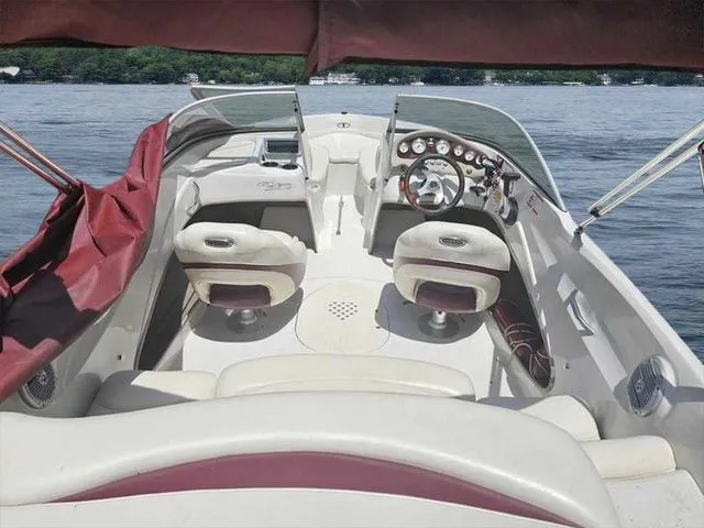 Slide: The Image of 2013 Tahoe Q5i boat interior with steering wheel, seats, and dashboard on a lake. - 10