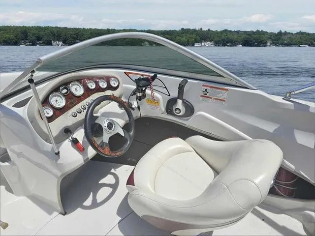 Slide: The Image of 2013 Tahoe Q5i boat cockpit with steering wheel and gauges on a lake. - 12