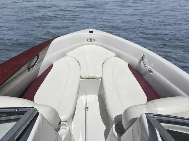 Slide: The Image of 2013 Tahoe Q5i boat interior with white and maroon seating on calm water. - 7